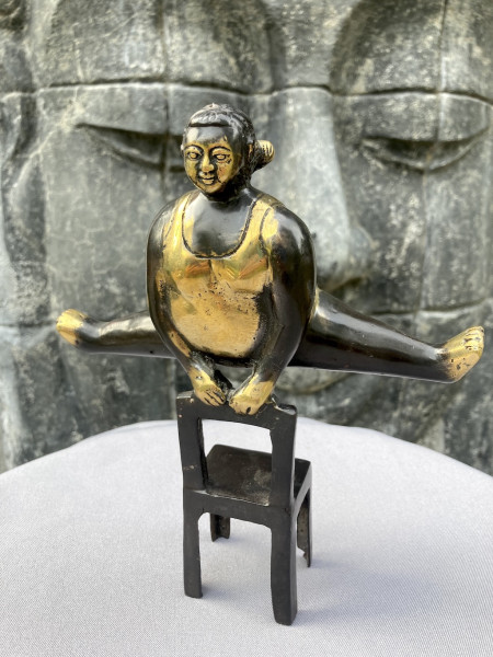 Yoga Madame macht Spagat auf Stuhl